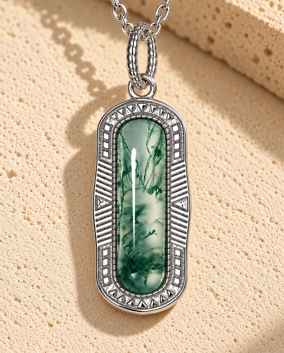 Moss Agate Bar Necklace in 925 Sterling Silver - lying on a cream textured surface beside a travertine block