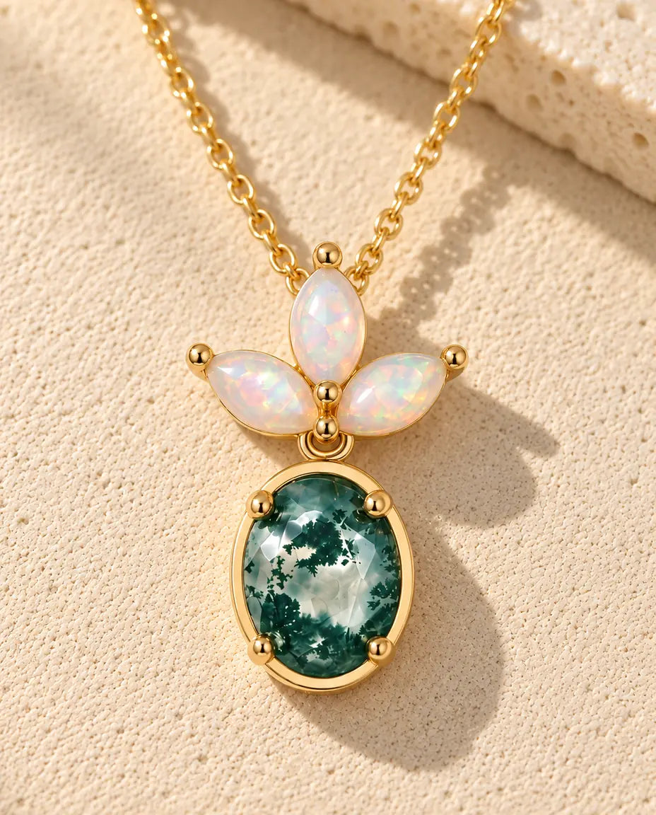 Moss Agate and Opal Drop Necklace in Gold Plated 925 Sterling Silver - lying on a cream textured surface beside a travertine block