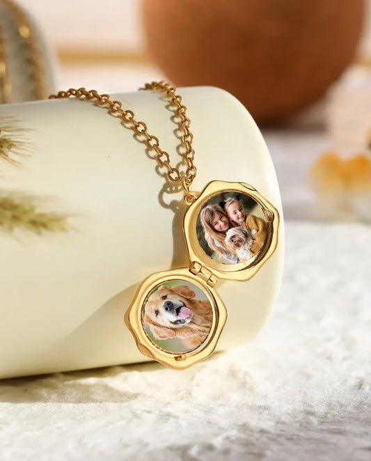 Paw print locket open showing two round photos of a dog and a family inside