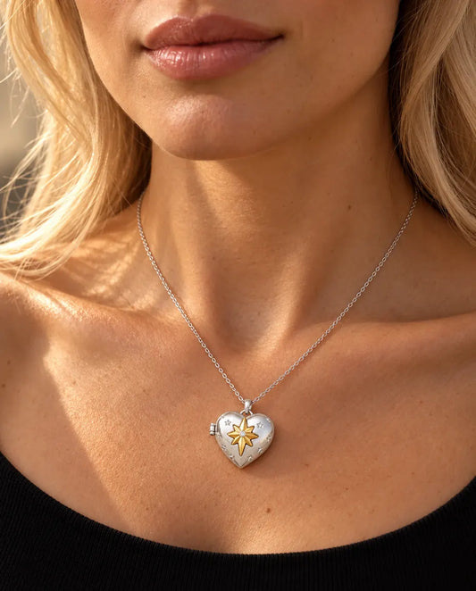 Woman in a black knit top wearing the silver tone north star heart photo locket necklace