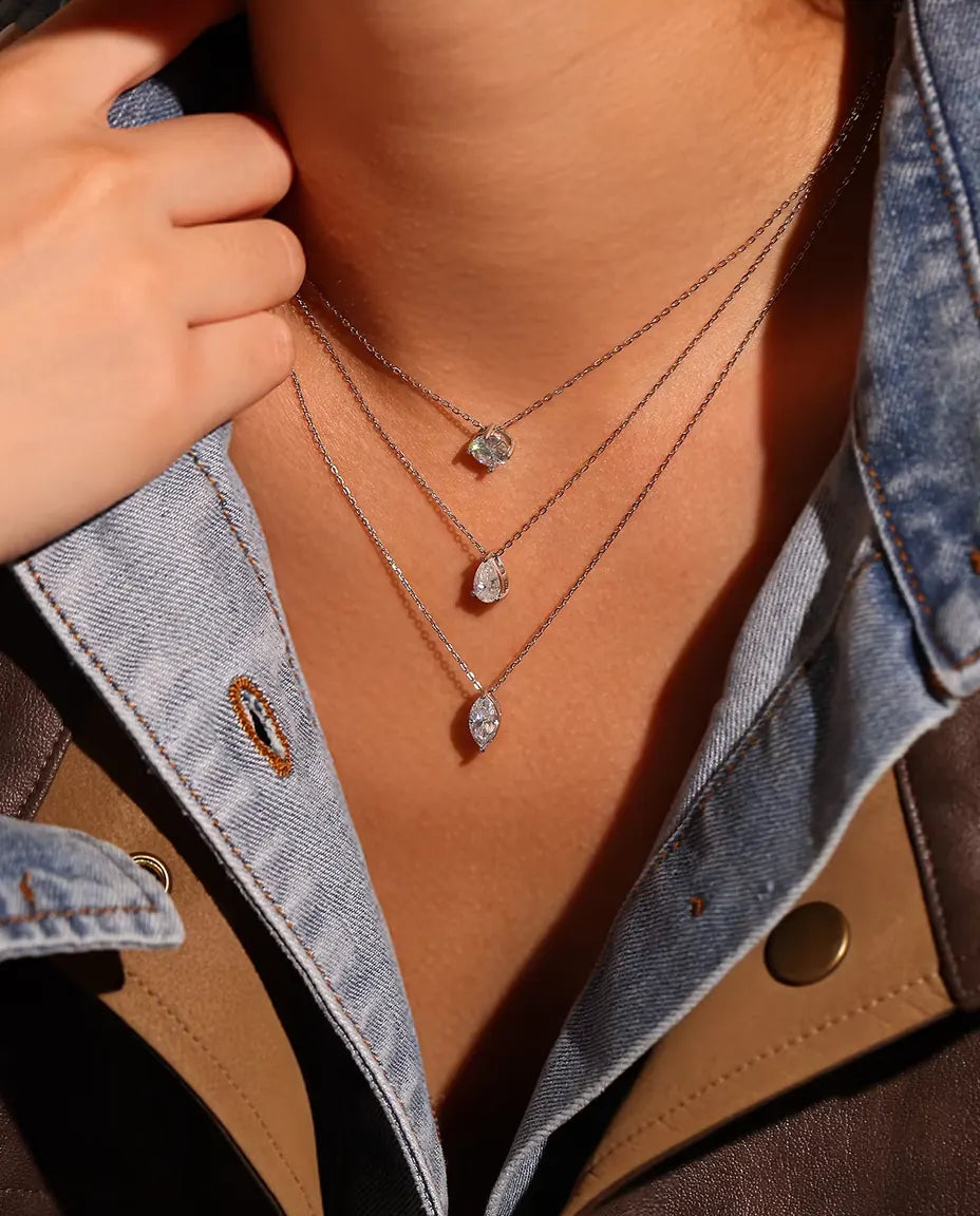 1 ct Marquise Moissanite Necklace in 925 Sterling Silver - worn on a model, layered with other necklaces