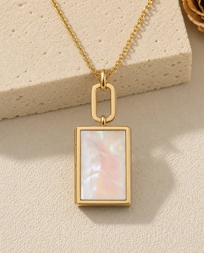 Gold book shaped photo locket necklace with a mother of pearl front