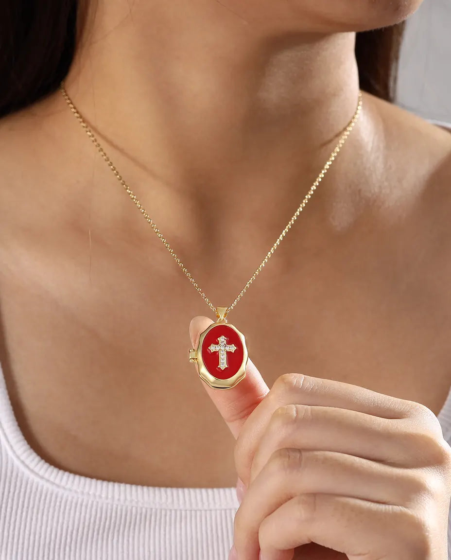 Model wearing red enamel cross photo locket necklace in gold tone