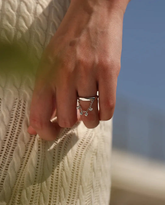 Sterling silver charm ring with draped chain and bezel set cubic zirconia drops