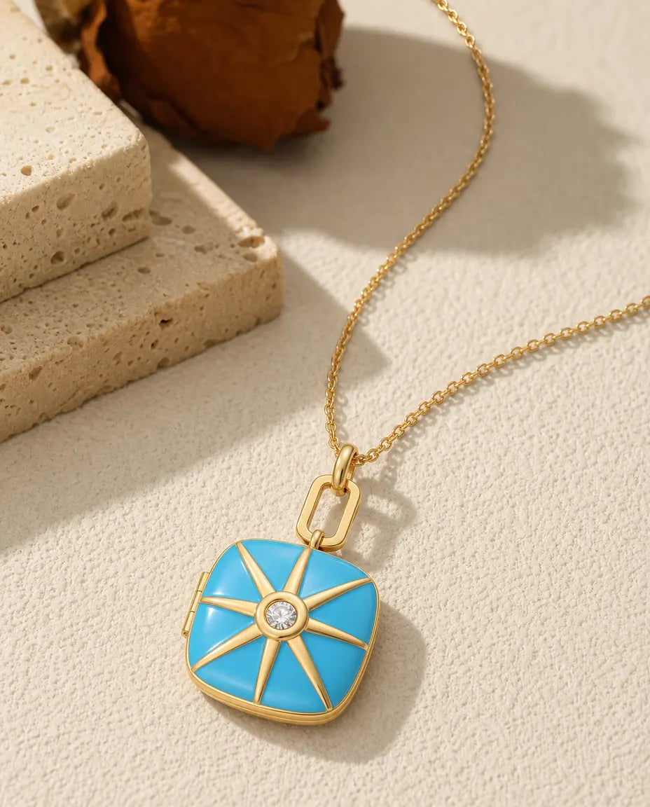 Turquoise enamel photo locket necklace with a gold starburst and crystal centre