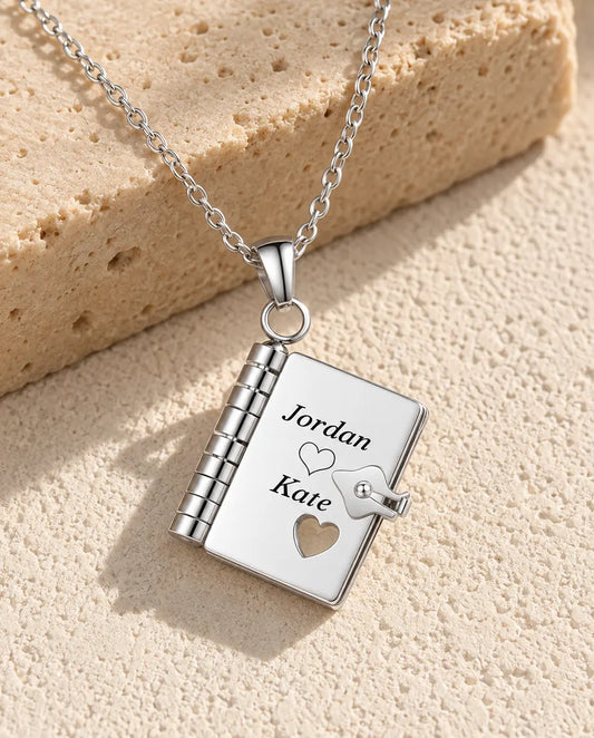 Personalised book locket necklace in silver stainless steel, front cover engraved with two names and a heart