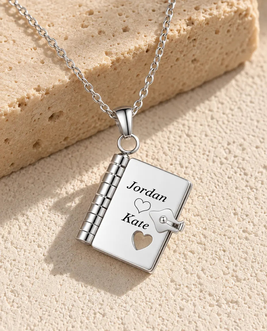 Personalised book locket necklace in silver stainless steel, front cover engraved with two names and a heart