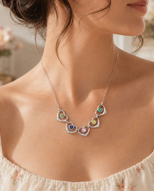 Woman wearing the family birthstone necklace with linked hearts