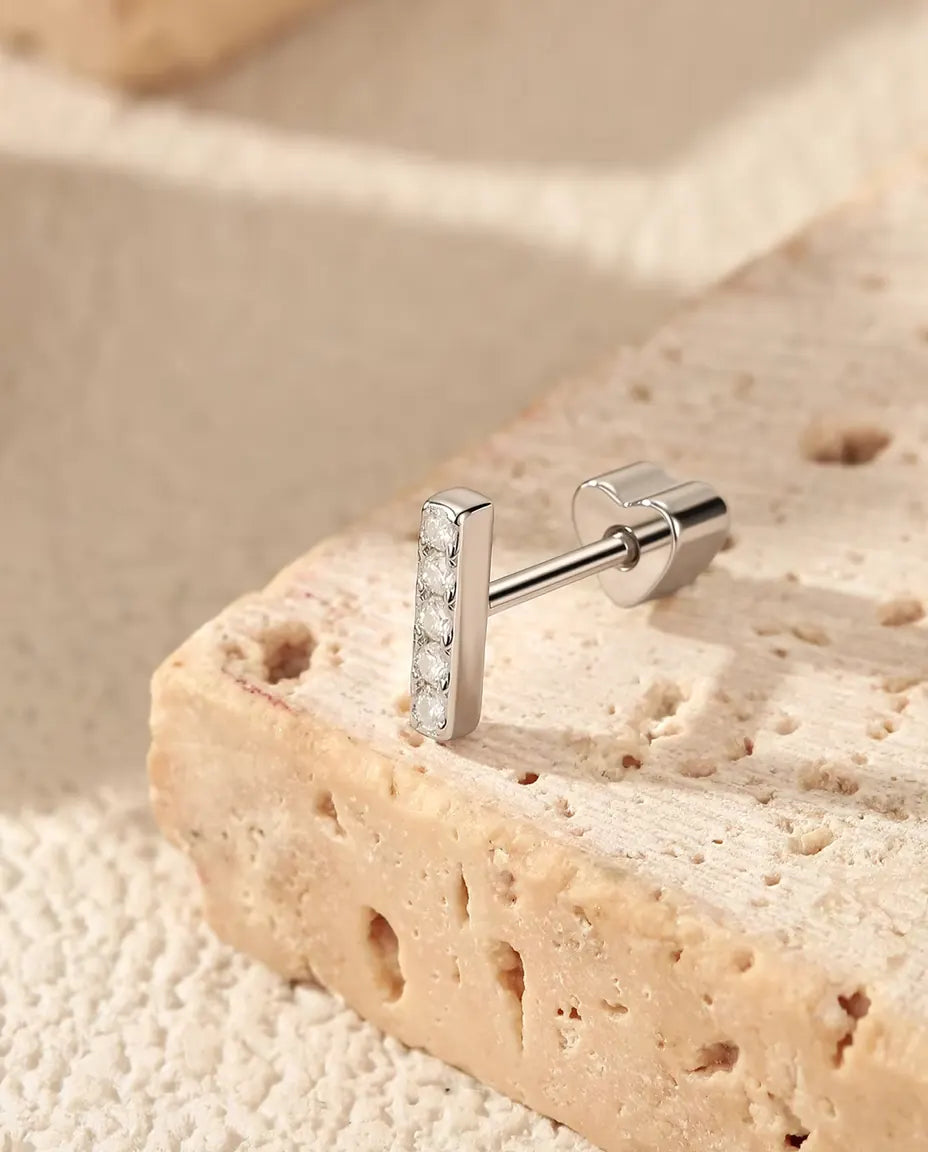Moissanite Bar Stud Earrings in 925 Sterling Silver - standing on the edge of a travertine slab