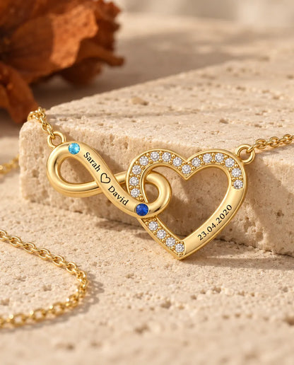 Gold infinity heart necklace photographed from a low angle