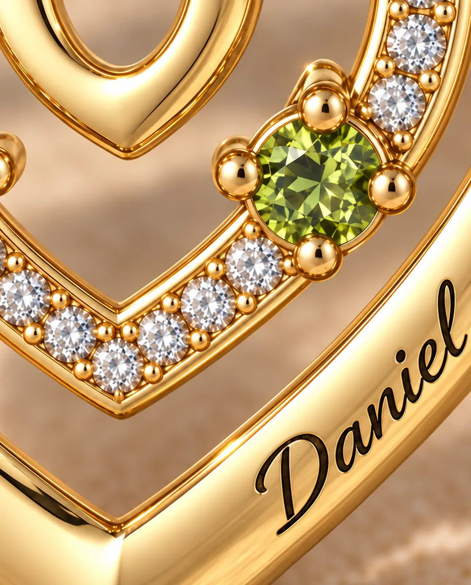 Macro detail of the two round birthstones and the engraved name on the outer heart