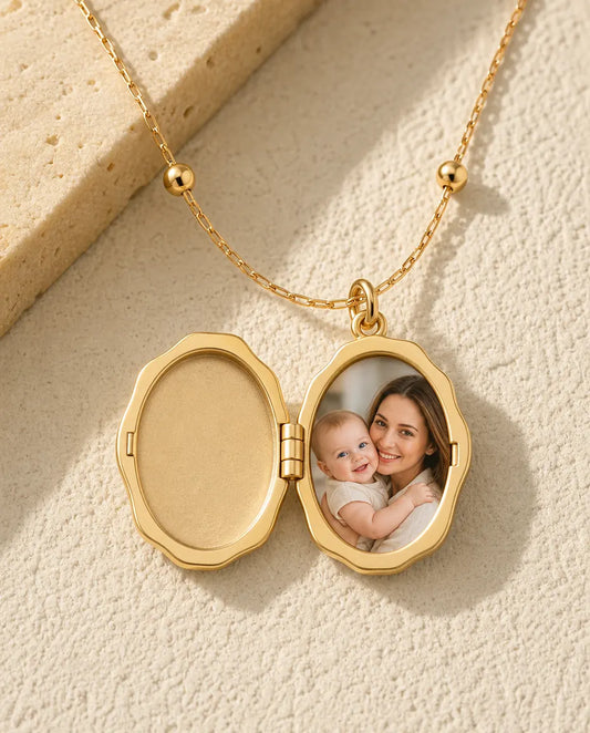 Gold cherub photo locket opened to show one picture of a mother and baby inside