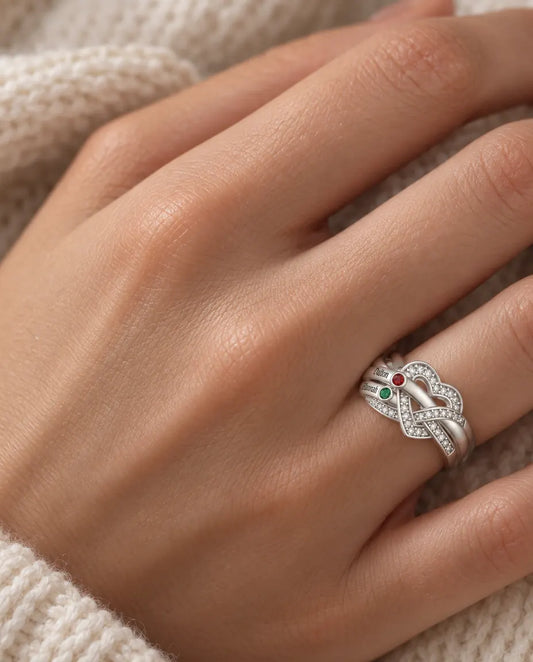 woman wearing personalised heart knot birthstone ring with 2 engraved names on her ring finger