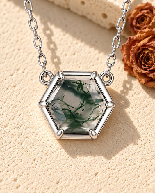 Hexagon Moss Agate Necklace in 925 Sterling Silver - lying on a cream textured surface beside a travertine block