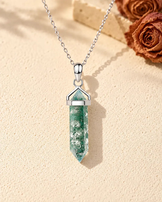 Hexagon Point Moss Agate Necklace in 925 Sterling Silver - lying on a cream textured surface beside a travertine block