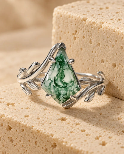 Kite-Cut Moss Agate Ring - displayed on a travertine block
