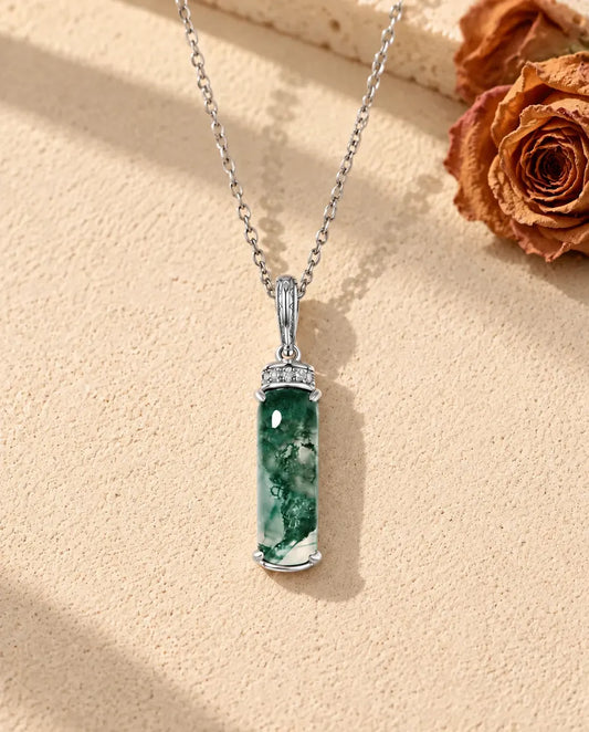 Moss Agate Bar Necklace in 925 Sterling Silver - lying on a cream textured surface beside a travertine block