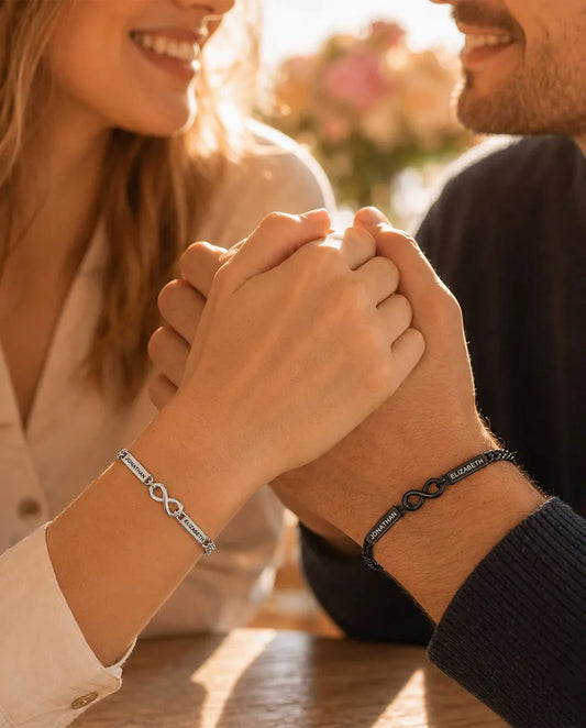 Personalised Infinity Couple Bracelets With 2 Engraved Names - Matching Silver & Black Name Bar Bracelet Set - worn by a couple holding hands
