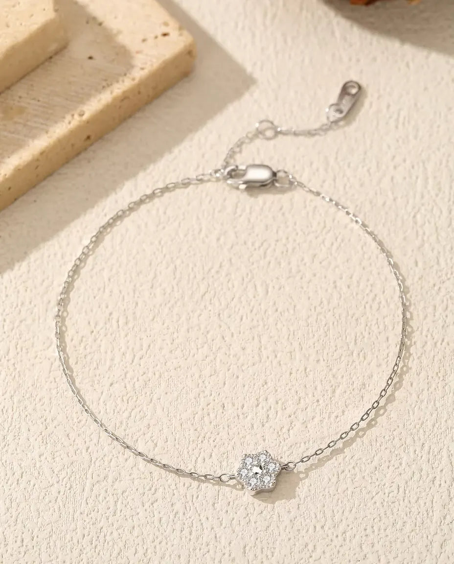 Moissanite Flower Bracelet in 925 Sterling Silver - laid flat on a cream textured surface with the clasp and extender