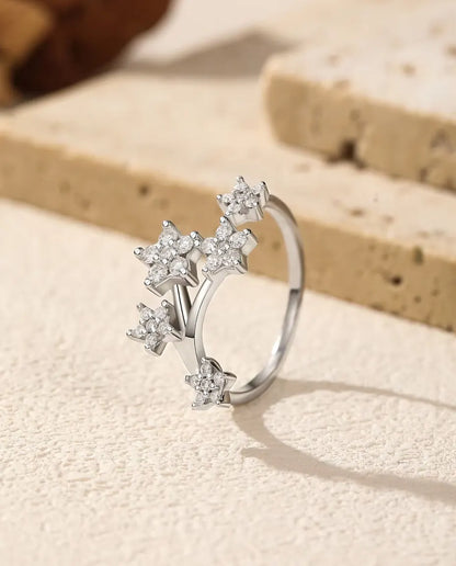 Moissanite Star Cluster Ring in 925 Sterling Silver - standing upright on a cream textured surface