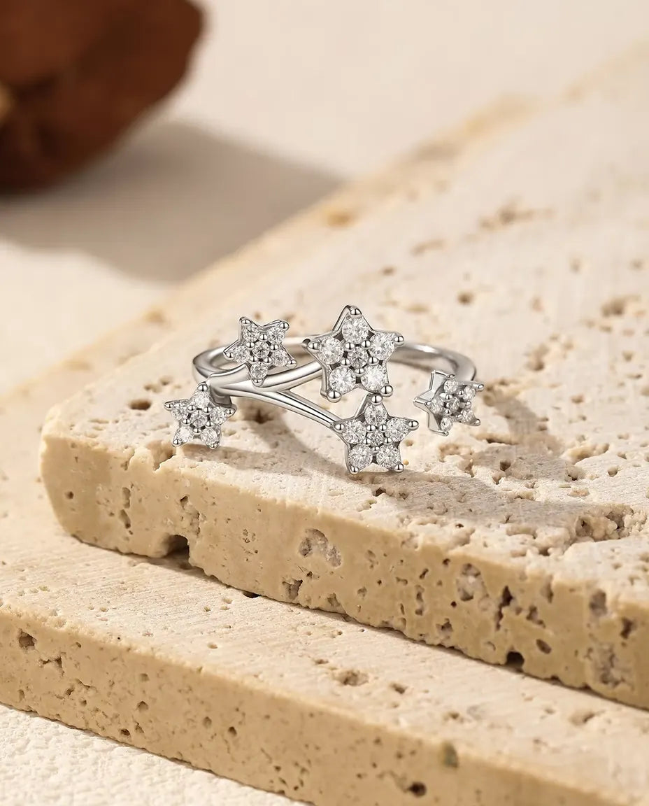 Moissanite Star Cluster Ring in 925 Sterling Silver - resting on the edge of a travertine slab