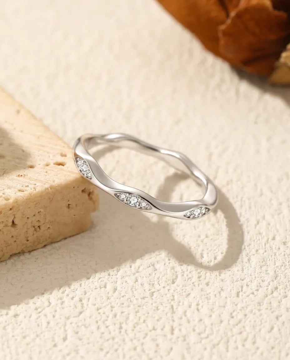 Moissanite Wave Ring in 925 Sterling Silver - resting on the edge of a travertine slab