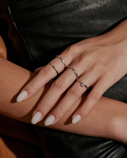Moissanite Wave Ring in 925 Sterling Silver - worn together with other rings, hands resting on each other