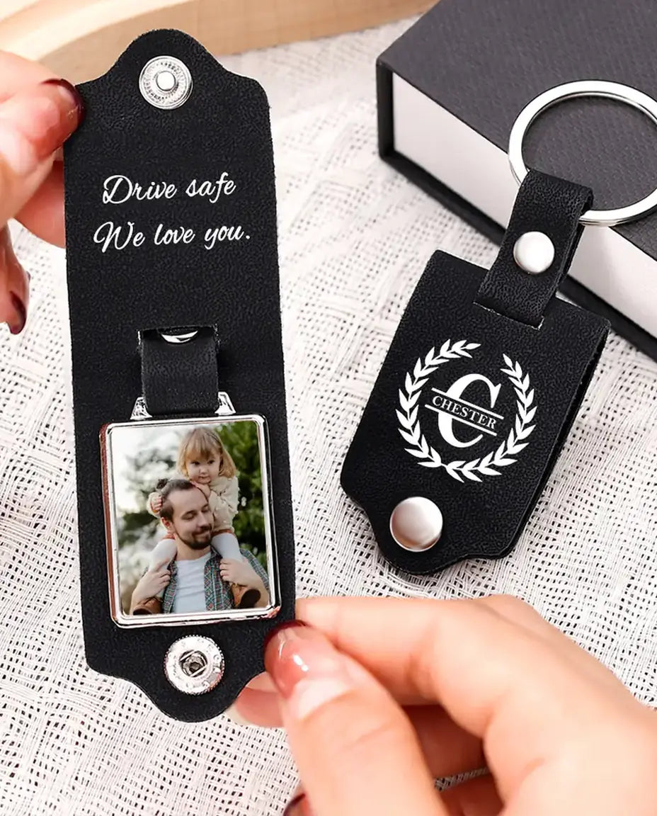 Hands opening the black faux leather keyring to show the photo inside