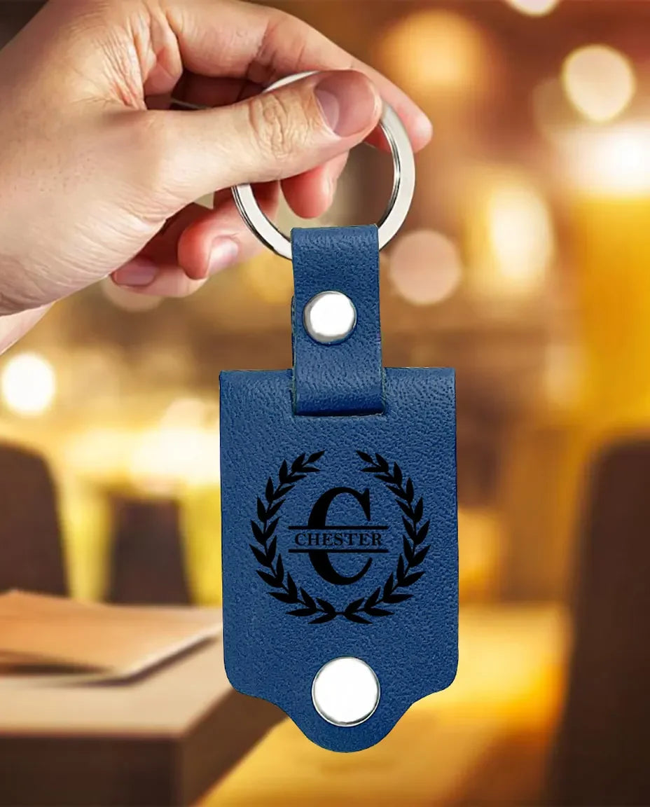 Hand holding the blue faux leather monogram photo keyring