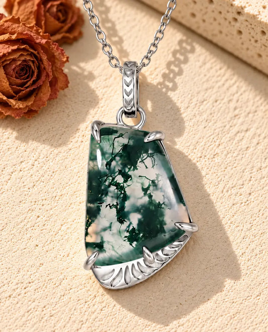 Moss Agate Slab Necklace in 925 Sterling Silver - lying on a cream textured surface beside a travertine block