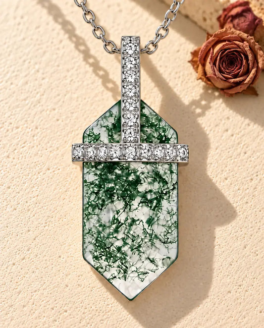 Moss Agate Hexagon Bar Necklace in 925 Sterling Silver - lying on a cream textured surface beside a travertine block