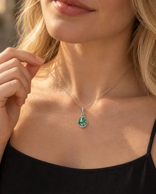 Moss Agate Shield Necklace in 925 Sterling Silver - worn on a model holding the chain with her fingertips
