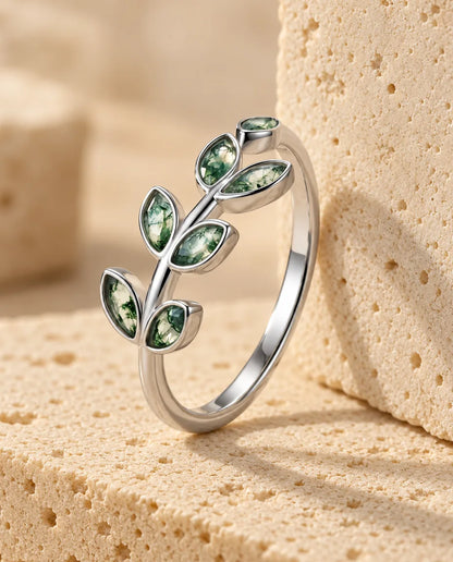 Olive Branch Moss Agate Ring - displayed on a travertine block