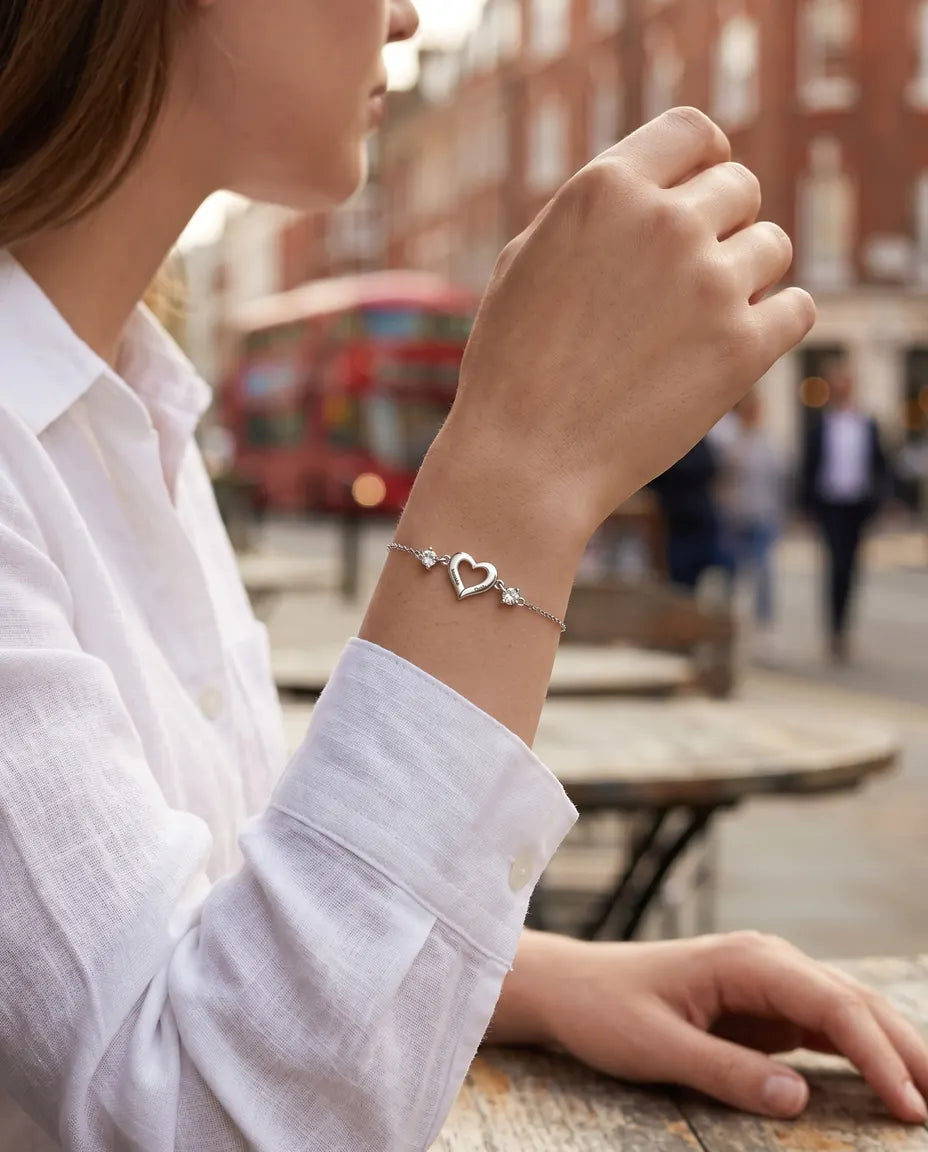 Open heart name bracelet worn with a white shirt