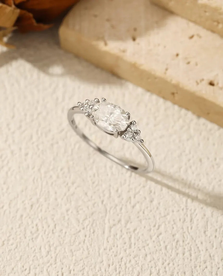 1 carat oval moissanite engagement ring in 925 sterling silver with zirconia side clusters