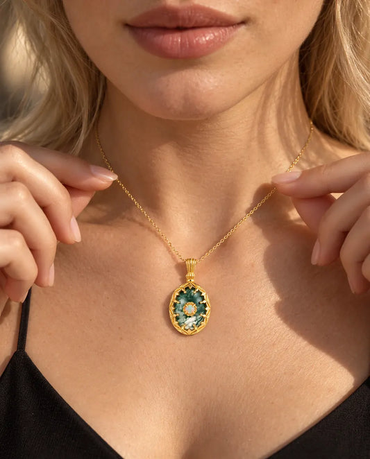 Oval Moss Agate Pendant Necklace in 10K Gold Plated 925 Sterling Silver - worn on a model holding the chain with her fingertips