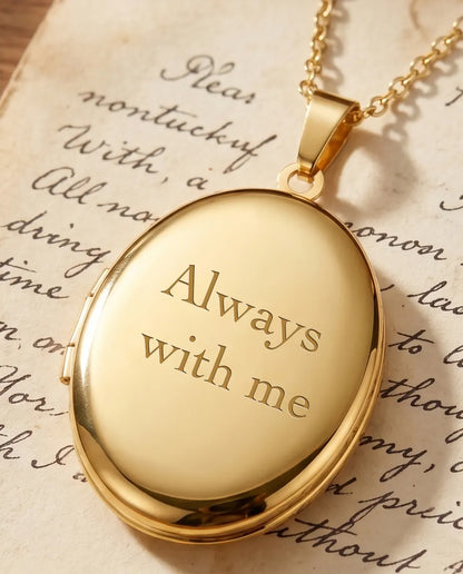 Gold oval locket back engraved with Always with me over a handwritten letter