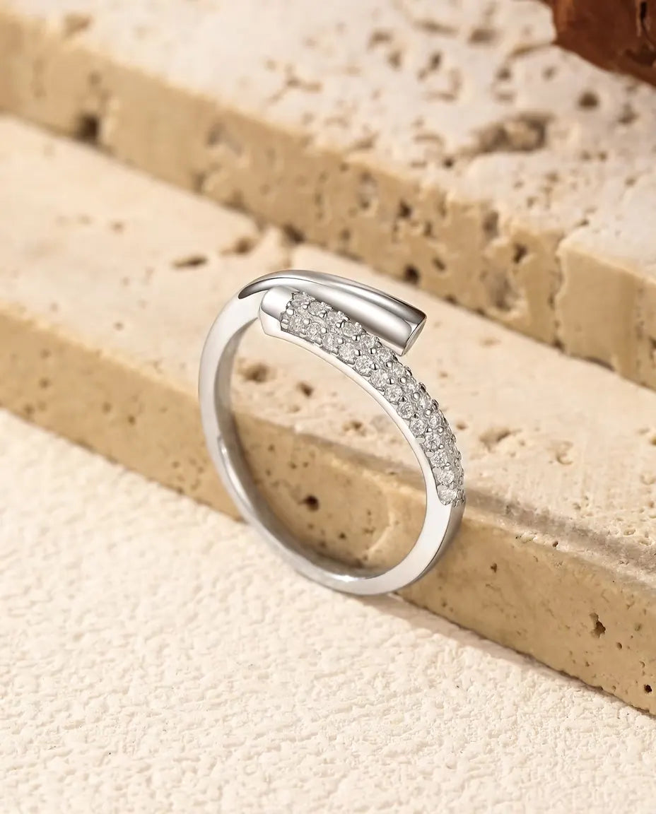 Pave Moissanite Bypass Ring in 925 Sterling Silver - resting on the edge of a travertine slab