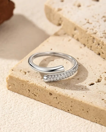 Pave Moissanite Bypass Ring in 925 Sterling Silver - lying on a travertine slab