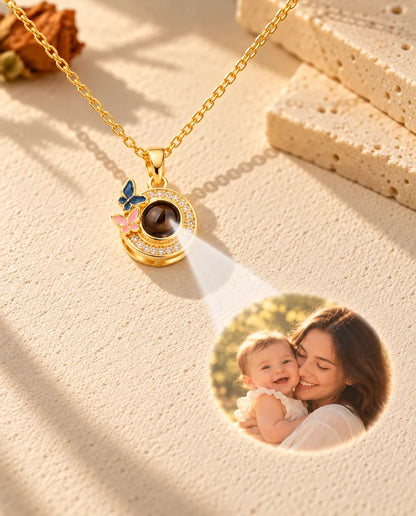 Light shining through the brown stone of the gold tone butterfly pendant projects a photo of a mother and baby