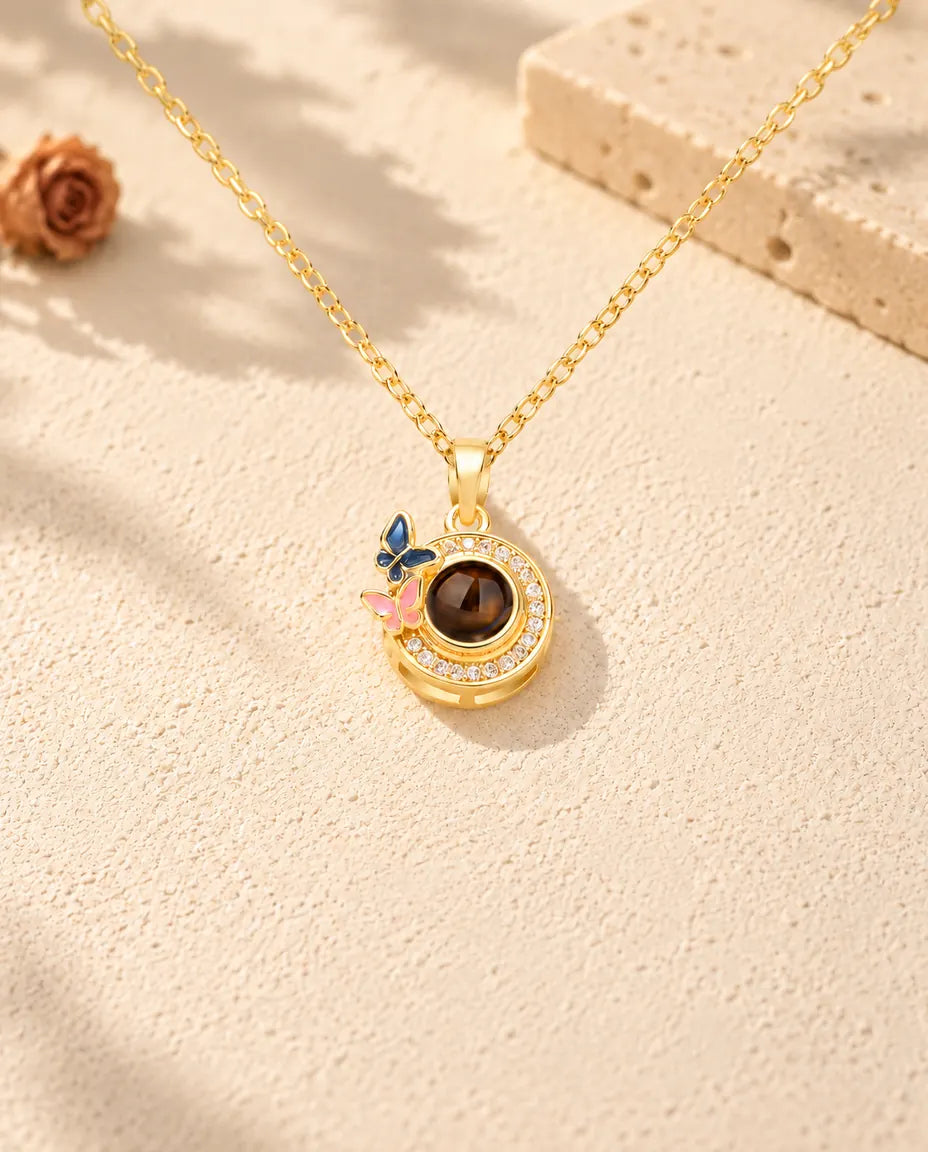 Front view of the gold tone butterfly halo circle photo projection necklace
