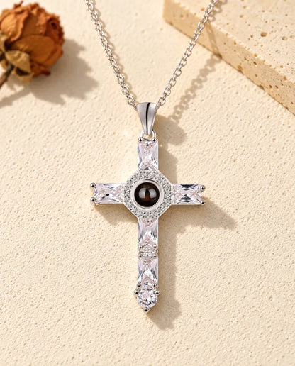 Front view of the silver tone cross with a halo around the projection stone