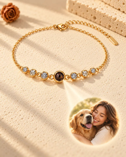 Light through the brown projection stone of the gold tone bracelet shows a round photo of a woman hugging her dog