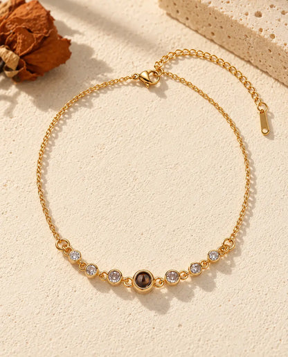 Top view of the gold tone cubic zirconia photo projection bracelet with its extender chain