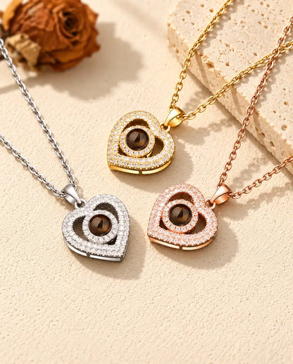 Gold tone, silver tone and rose gold tone double heart necklaces beside a travertine slab