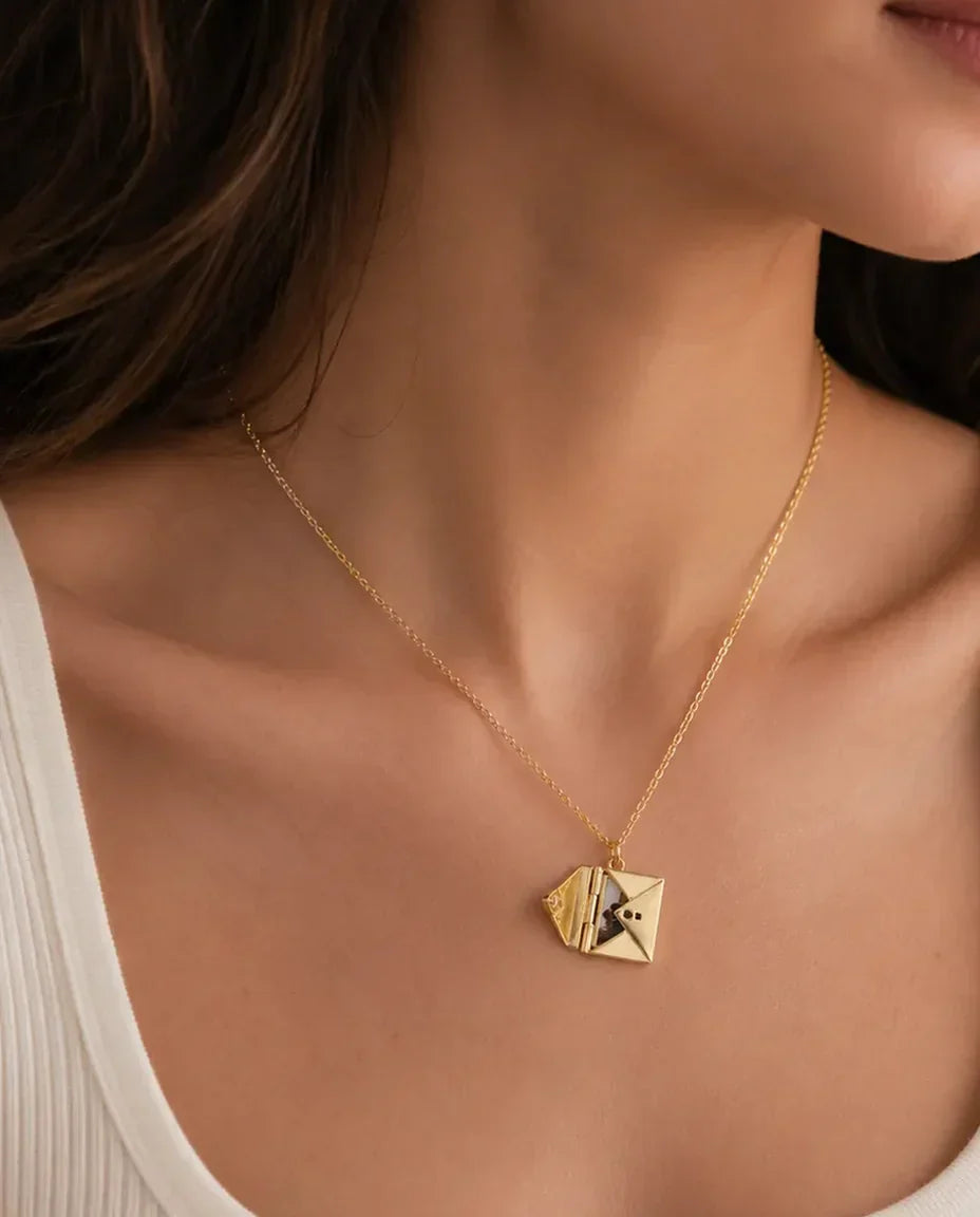 Woman wearing gold envelope photo locket necklace, opened to show the photo card