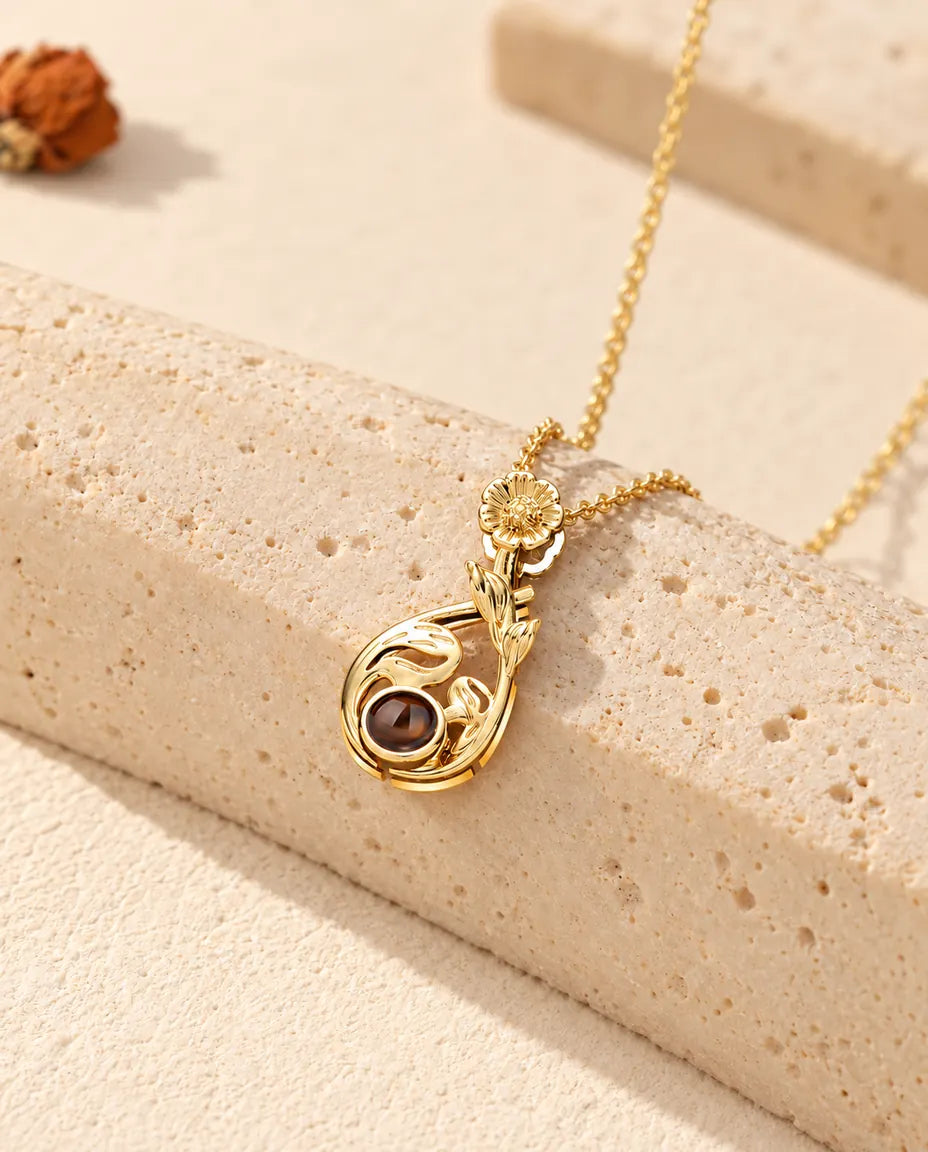 Personalised gold tone flower teardrop photo projection necklace with a daisy bail on travertine