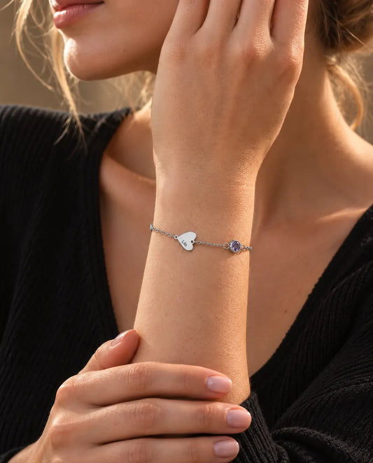 Woman wearing the heart name and birthstone bracelet with one engraved heart
