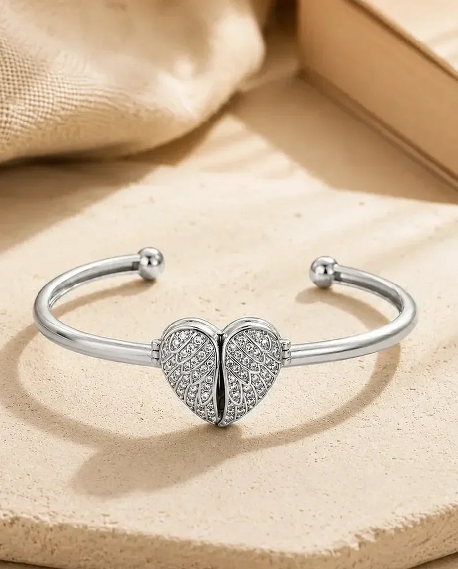 Silver cuff bangle with pave winged heart closed, flat lay