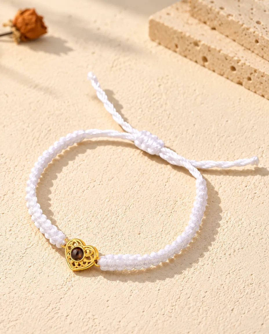 White braided cord photo projection bracelet with a gold tone heart charm and sliding knot closure